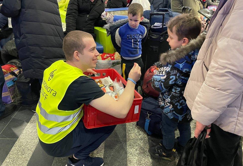 Volunteer handing out food to children