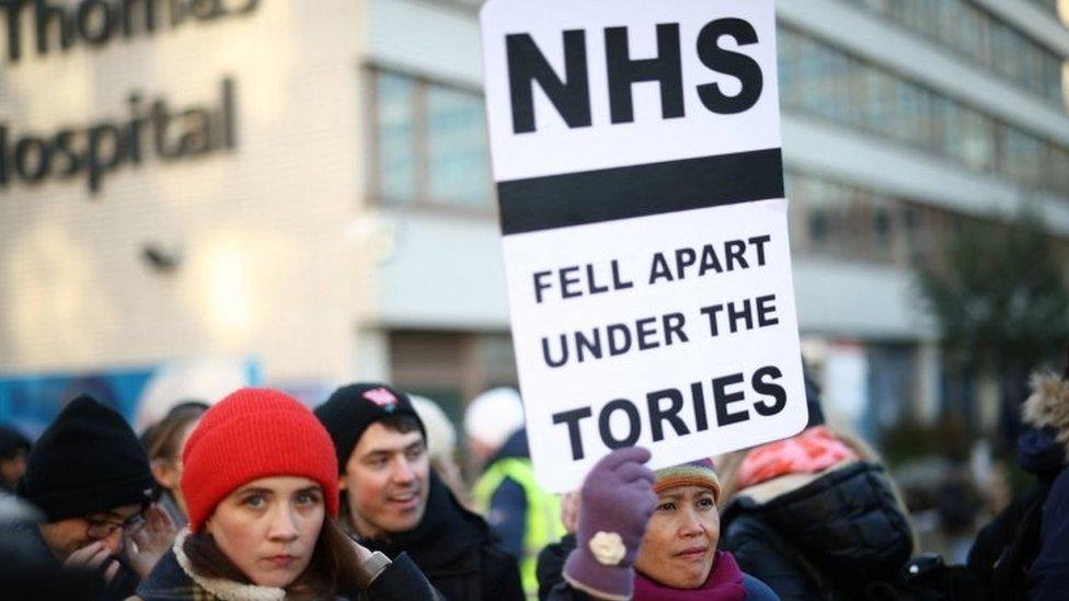 NHS nurse holds a placard during a strike