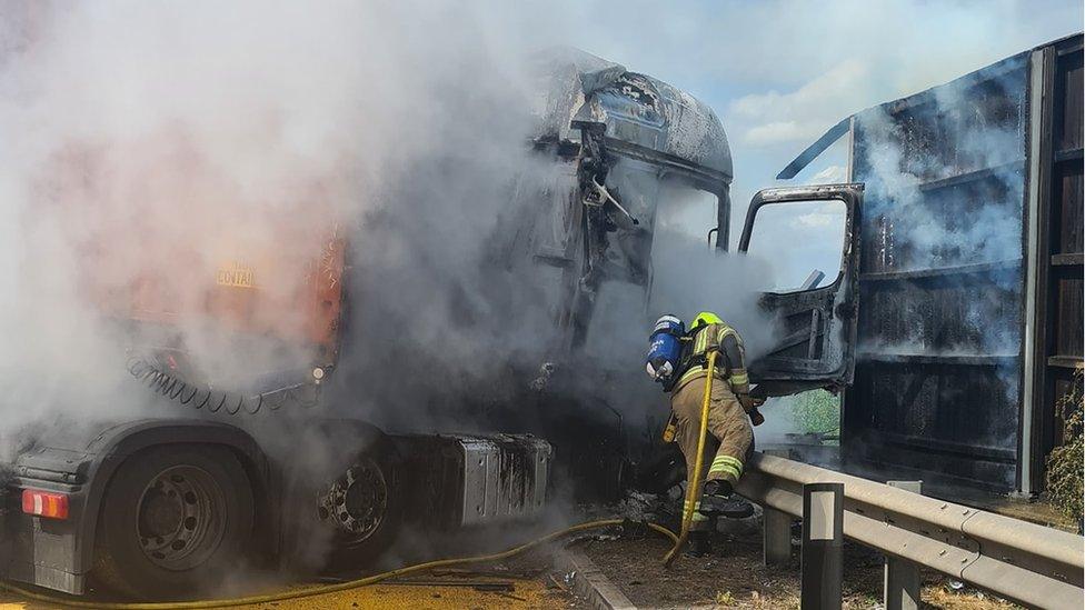 A firefighter by a lorry fire on the M1 by Luton