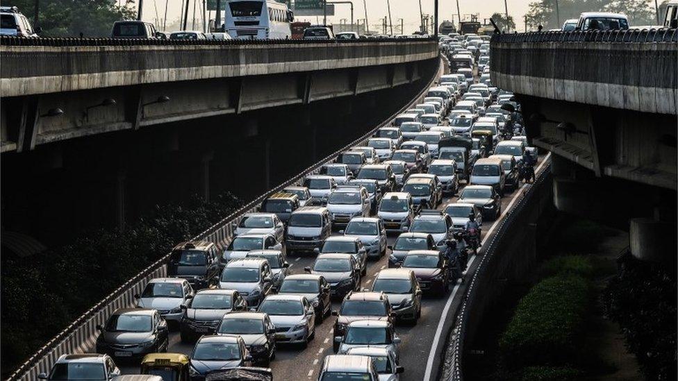 In this photo taken on October 15, 2015, cars back up on an exit to a highway in Delhi