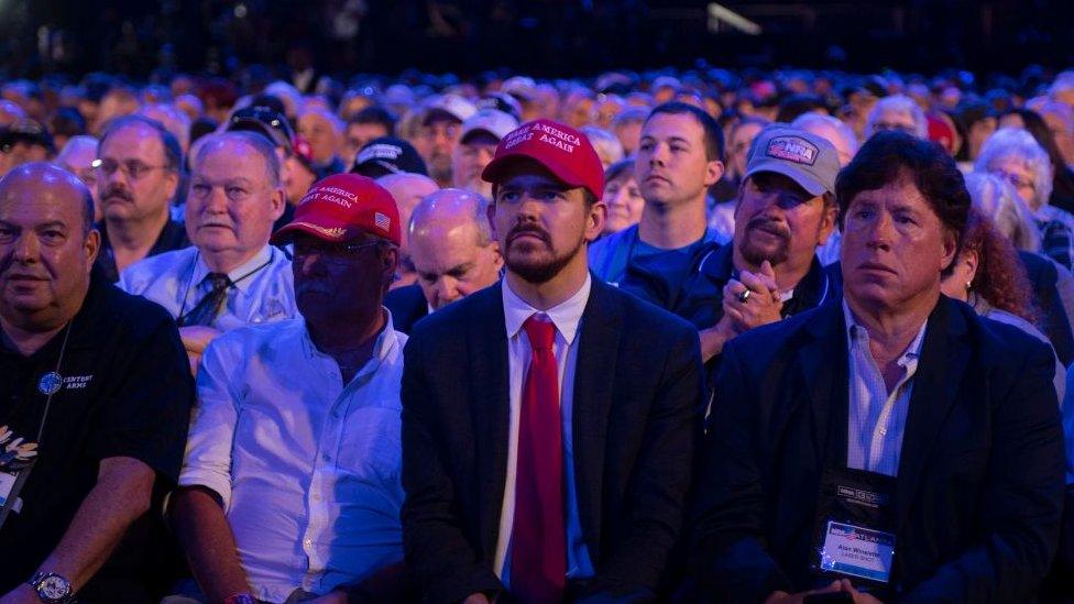 Members of the audience listen as US President Donald Trump addresses the National Rifle Association (NRA)