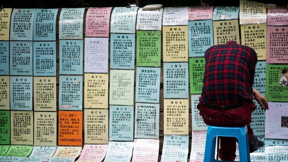 Worried parents place advertising notices for their single children at a "marriage market" in Shanghai