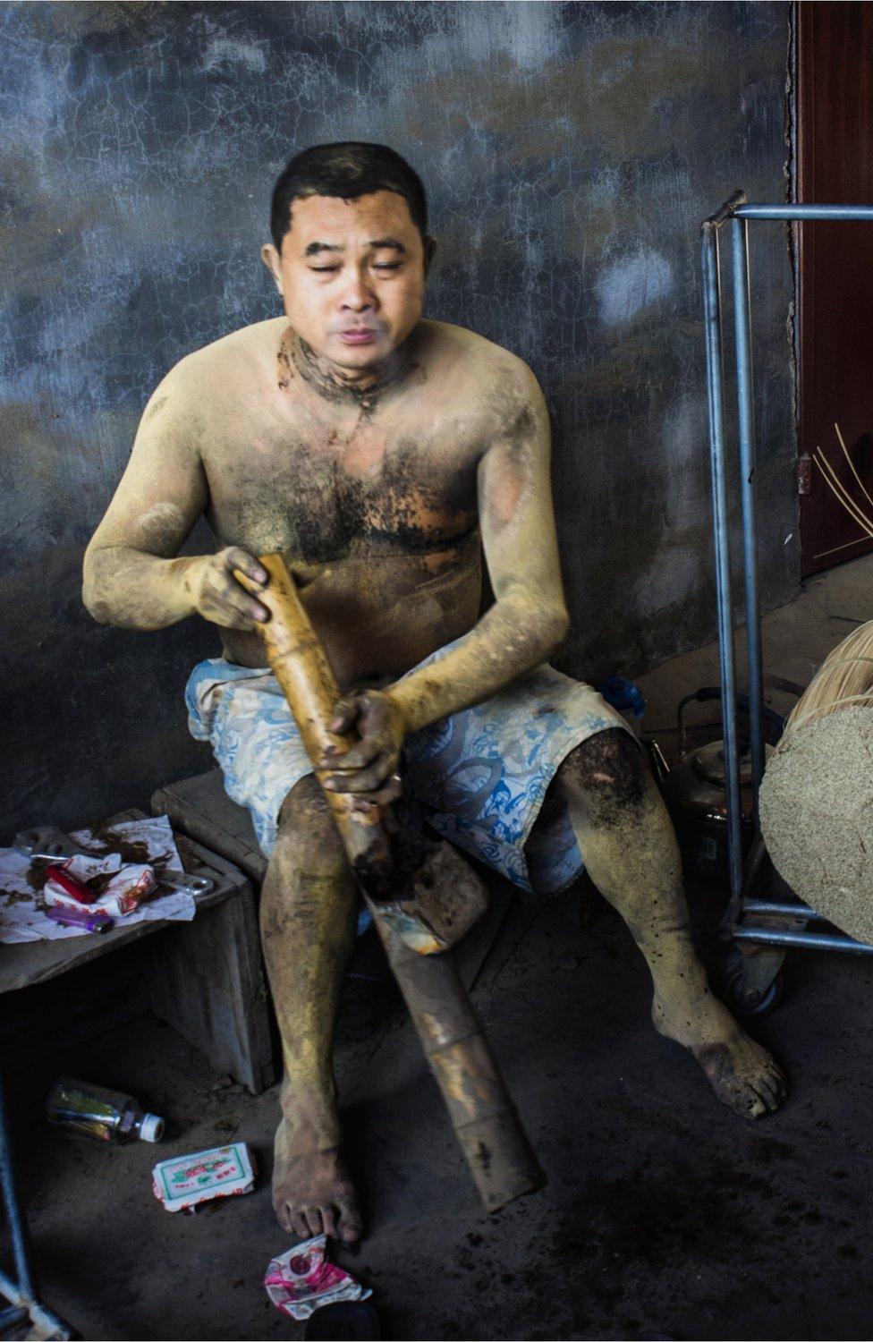 An incense worker sitting down on his break