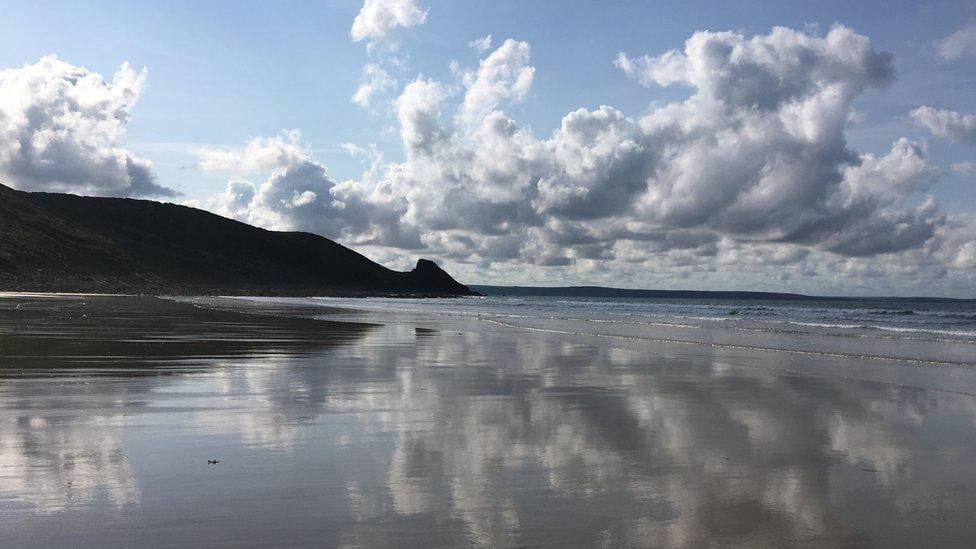 Clouds mirrored on Newgale beach in Pembrokeshire by Sue Pasternak