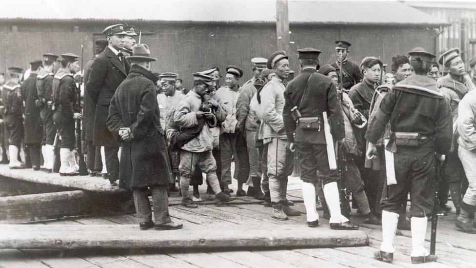 Japanese troops with captured Chinese men and boys in then Shangdong, China