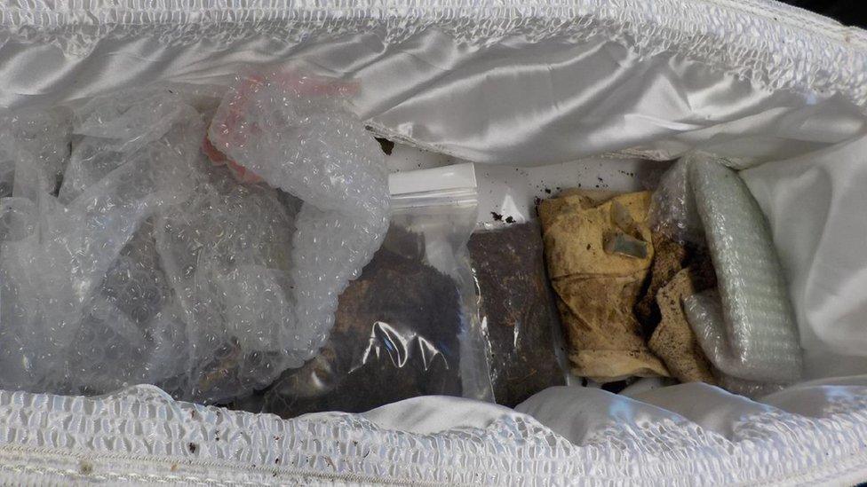 The exhumed coffin contained various items including a shroud and a cross