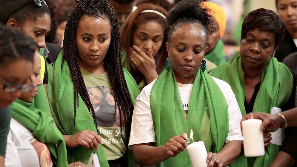 People light candles at memorial service