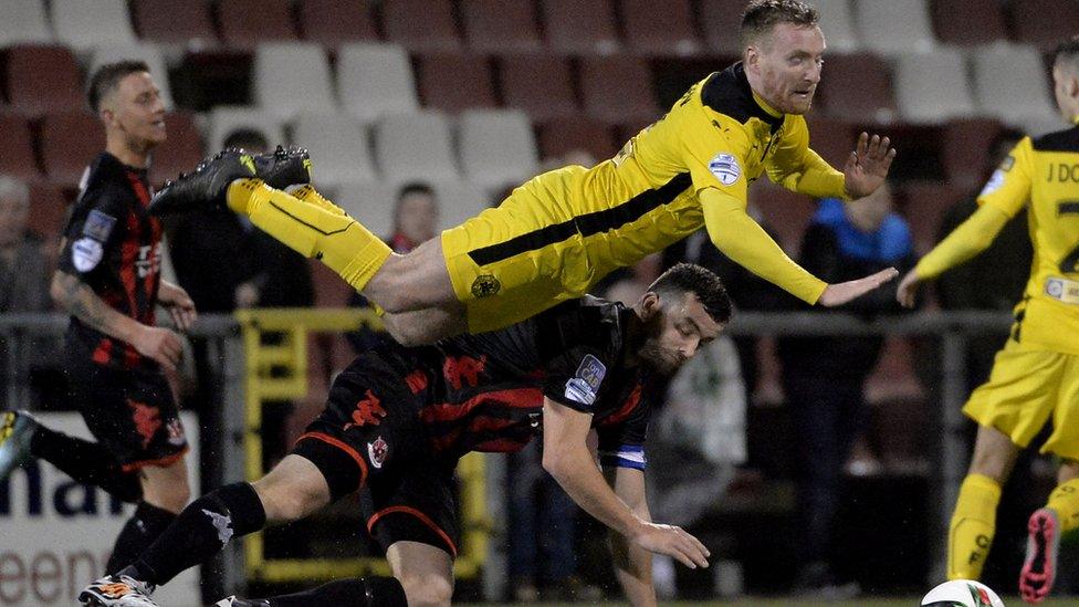 Chris Curran of Cliftonville takes a tumble after a challenge by Crusaders skipper Colin Coates during the 2-2 draw at Seaview