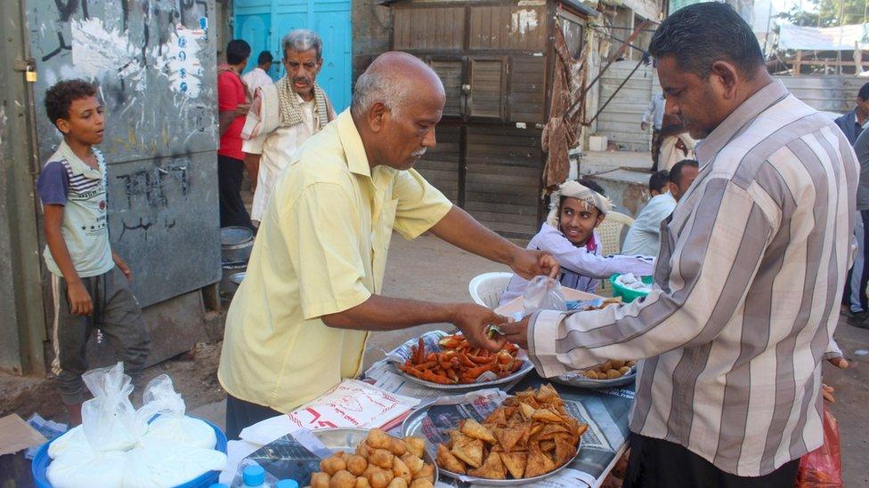 A man buys food at a market in Aden, Yemen (27 April 2020)