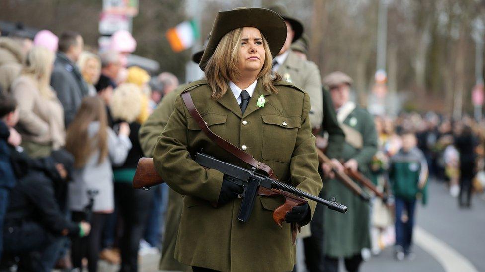 woman walks with rifle