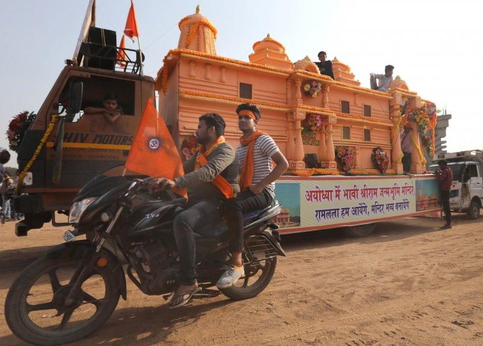 Indian Vishwa Hindu Parishad (VHP) supporters pass near a model of a Lord Rama temple which Vishwa Hindu Parishad demanded to be built in Ayodhya as they takes part in a religious procession organised by Vishwa Hindu Parishad (VHP) ahead of the Ram Navami festival in New Delhi, India