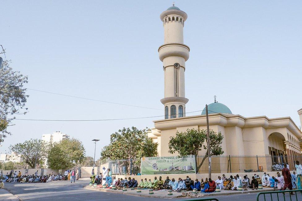 Worshippers arrive at the mosque in Dakar's Pointe E neighborhood in Dakar.