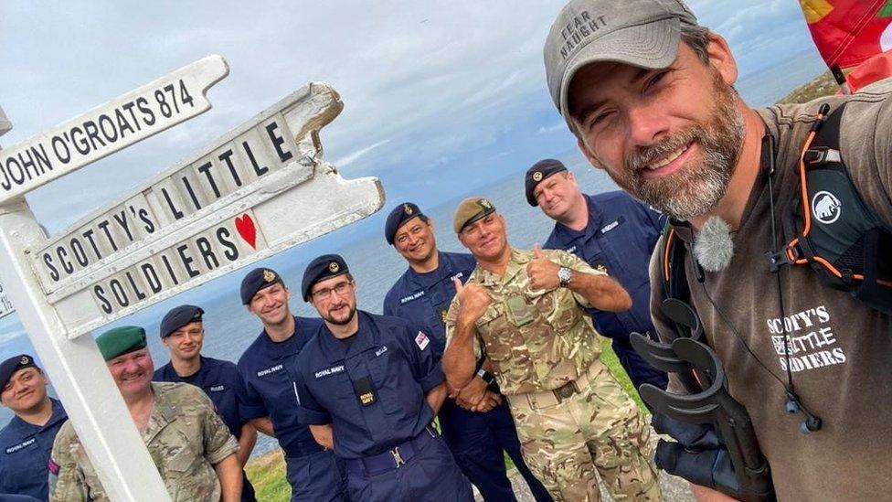 Mark Harding takes a selfie with various military personnel