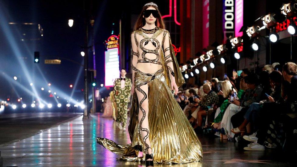 A model walks on the pavement of Hollywood Blvd during the Gucci Love Parade fashion show in Los Angeles, California