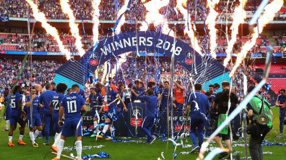 The Chelsea team and staff celebrate their victory with the Emirates FA Cup trophy following The Emirates FA Cup Final between Chelsea and Manchester United at Wembley Stadium on May 19, 2018 in London, England