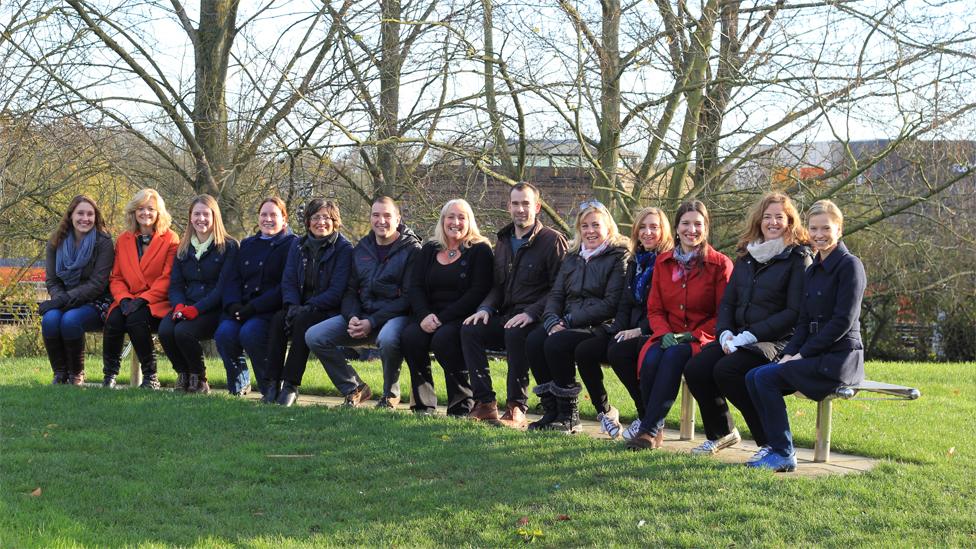 Trust Me I'm A Doctor's Chris Van Tulleken and some of the volunteers - sitting on a long park bench near the University of Surrey