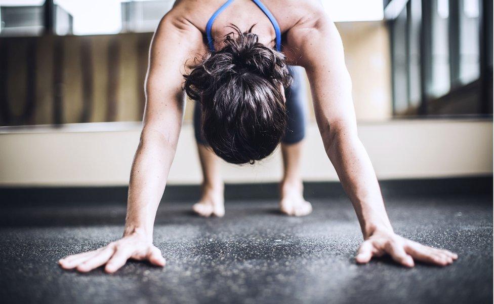 A woman in a downward-facing dog yoga position