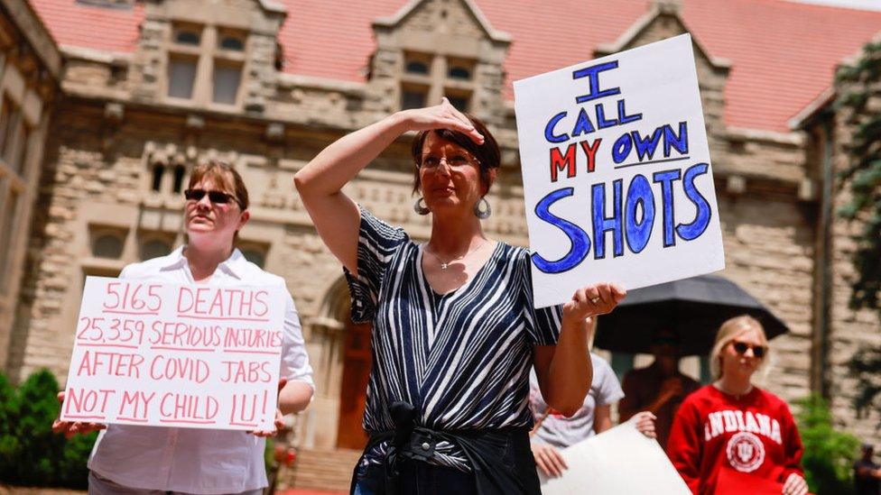 Protesters holding placards gather at Indiana University's Sample Gates during the demonstration. Anti-vaxxers and anti-maskers gathered at Indiana University's Sample Gates to protest against mandatory Covid vaccinations