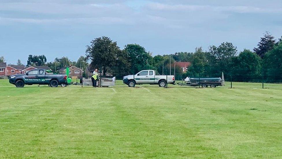 Contractors putting up fencing at a field in Rhosnesni, Wrexham