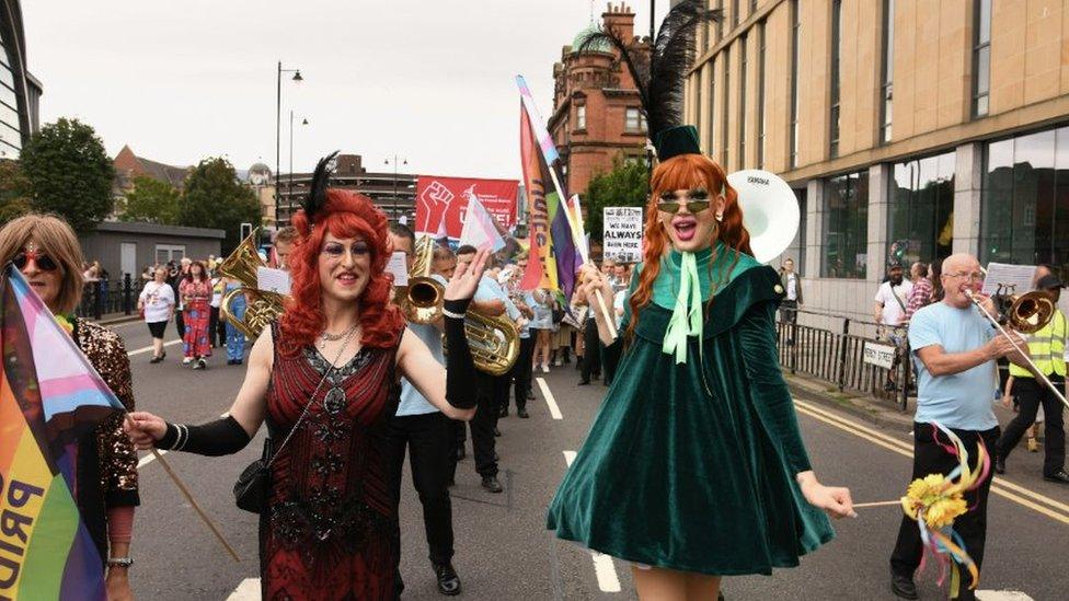 Two drag queens walk down the street