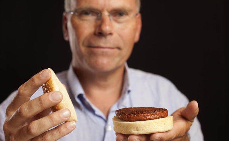 Dr Post holding the first lab-grown burger in a bun