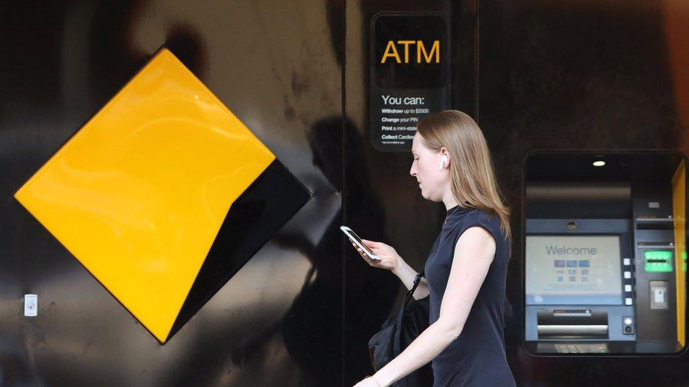 A woman walks past a Commonwealth Bank branch