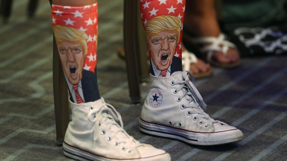 close up of supporter's legs wearing socks imprinted with Donald Trump's face