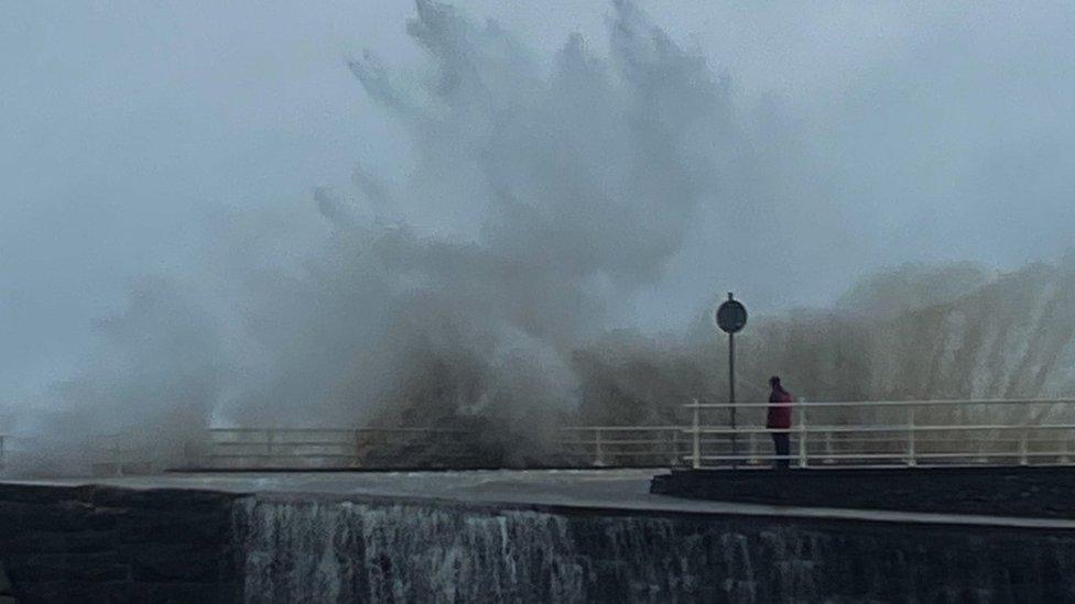 Wave crashes on to the front at Aberystwyth as a spectator looks on