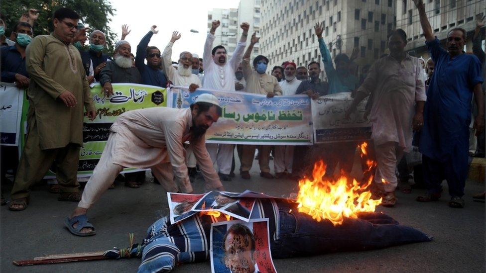 Protesters burning an effigy of Emmanuel Macron