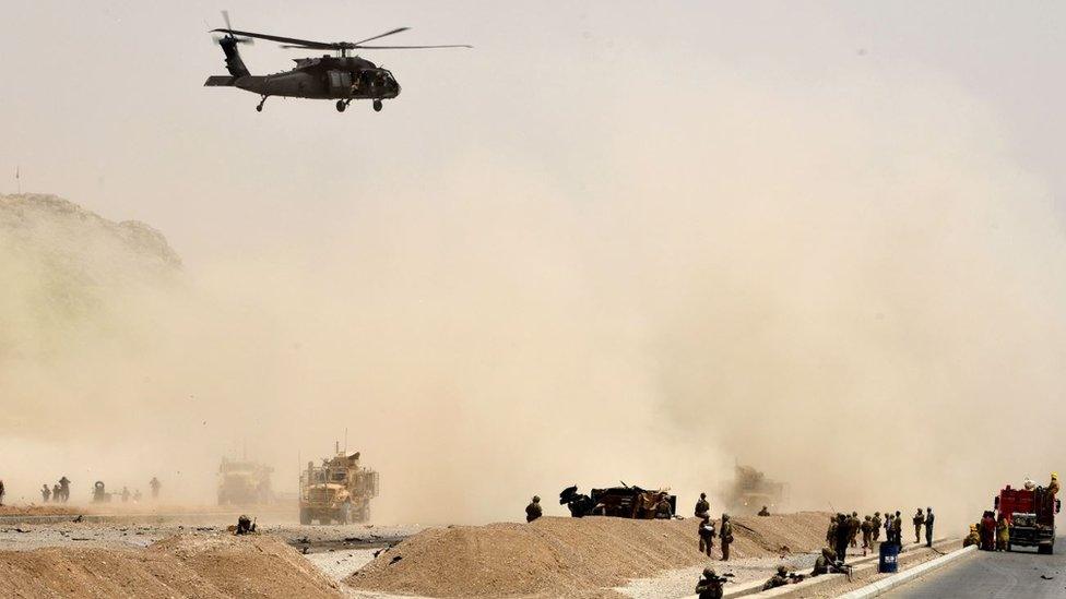 A US black hawk helicopter flies over the site of a Taliban suicide attack in Kandahar