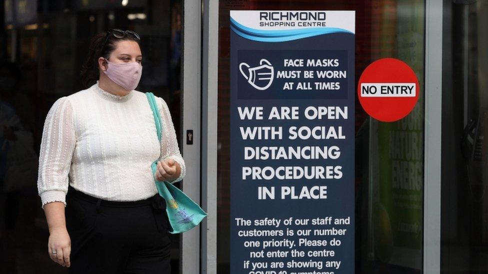 A woman walking out of a shop