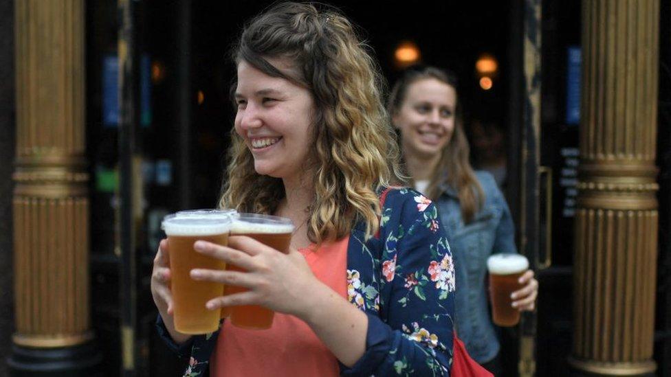 Woman carrying takeaway pints