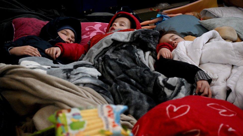 Refugees from Ukraine stay at the reception point established at the train station in Przemysl, Poland