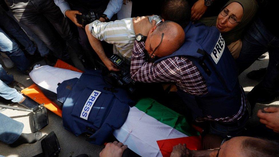 Journalists mourn next to the coffin of Al Jazeera correspondent Shireen Abu Aqla (11 May 2022)