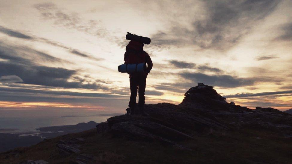 Charlie Russell stood on top of a mountain peak during training for the trek.