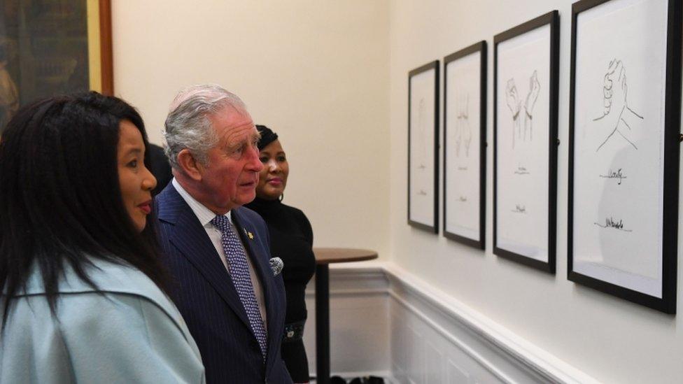 Prince Charles and Makaziwe Mandela look at drawings by Nelson Mandela on display in St Georges Hall in Liverpool