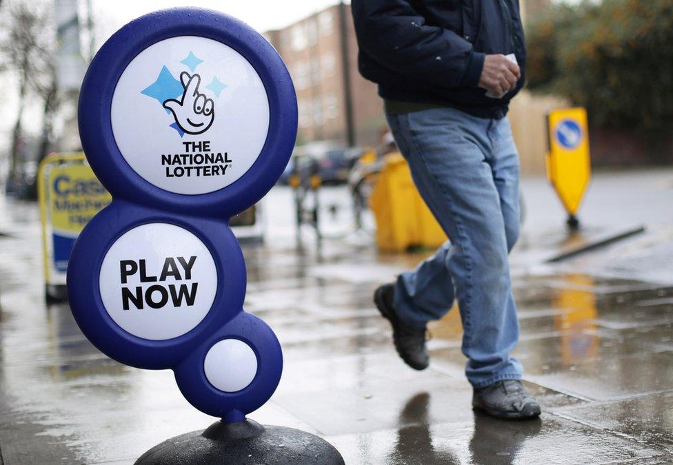 Person walks past lottery sign