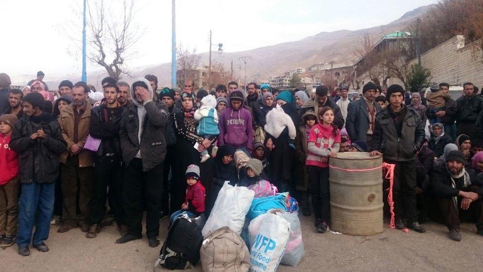 Syrians wait for the arrival of aid