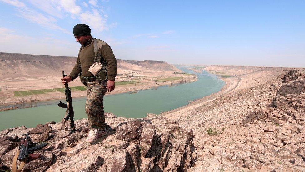 A Syrian Democratic Forces (SDF) fighter poses for a picture near the River Euphrates, north of Raqqa city, Syria (8 March 2017)