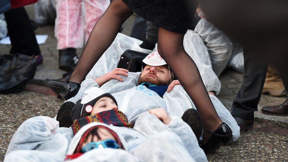 A woman tries to walk over protestors demonstrating against the EU-Canada Comprehensive Economic and Trade Agreement (Ceta) in front of the European Parliament in Strasbourg, eastern France, on 15 February 2017