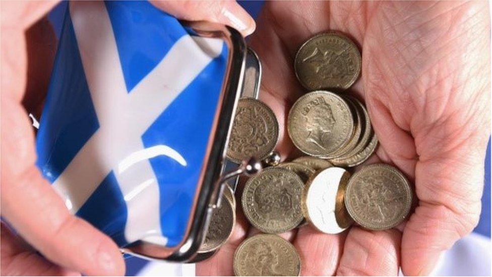 Coins are shaken from a purse with the Scottish flag on it