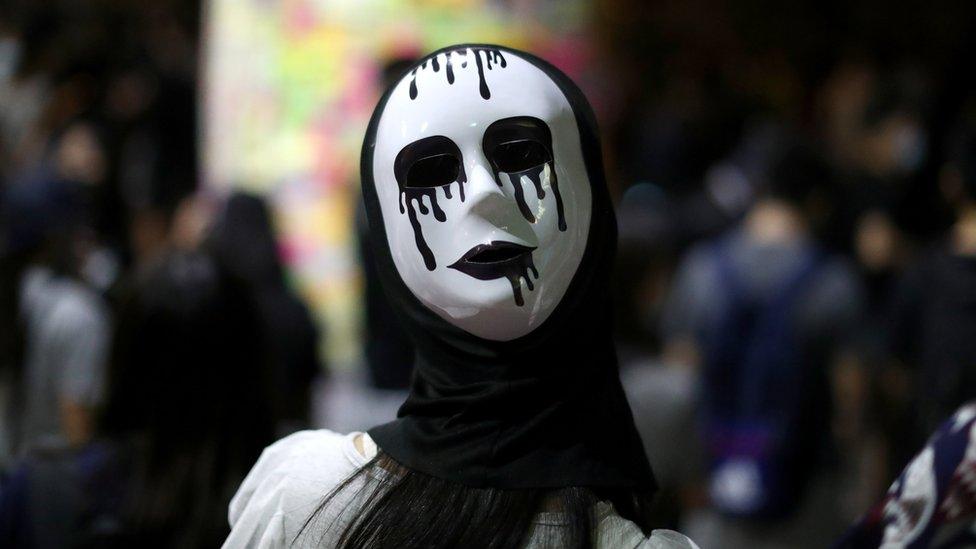 An anti-government protester wears a mask during a demonstration in Wong Tai Sin district, in Hong Kong