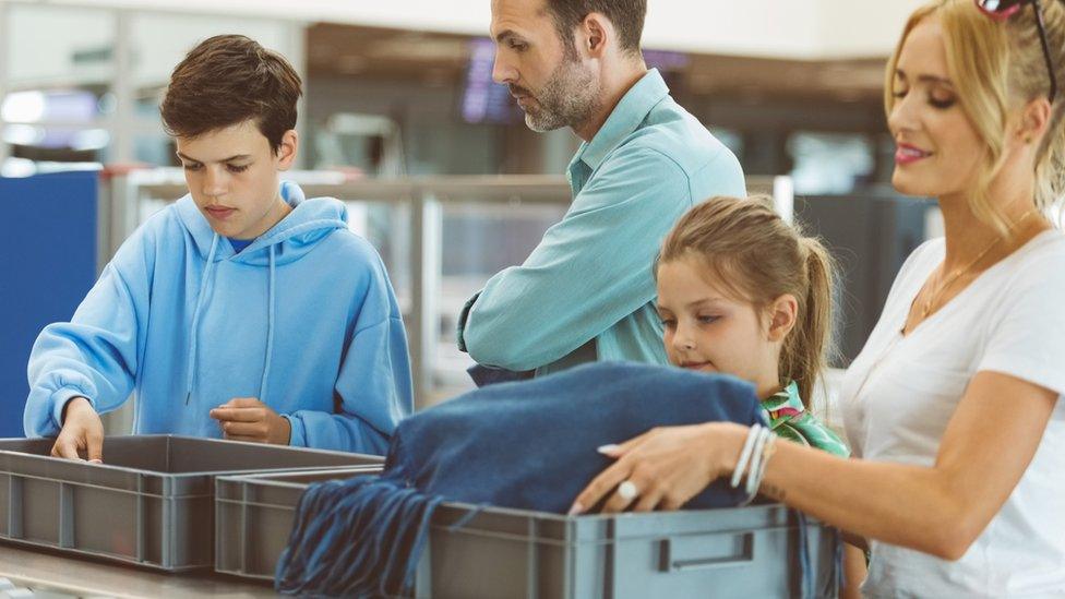 family-going-through-airport-security-checks.