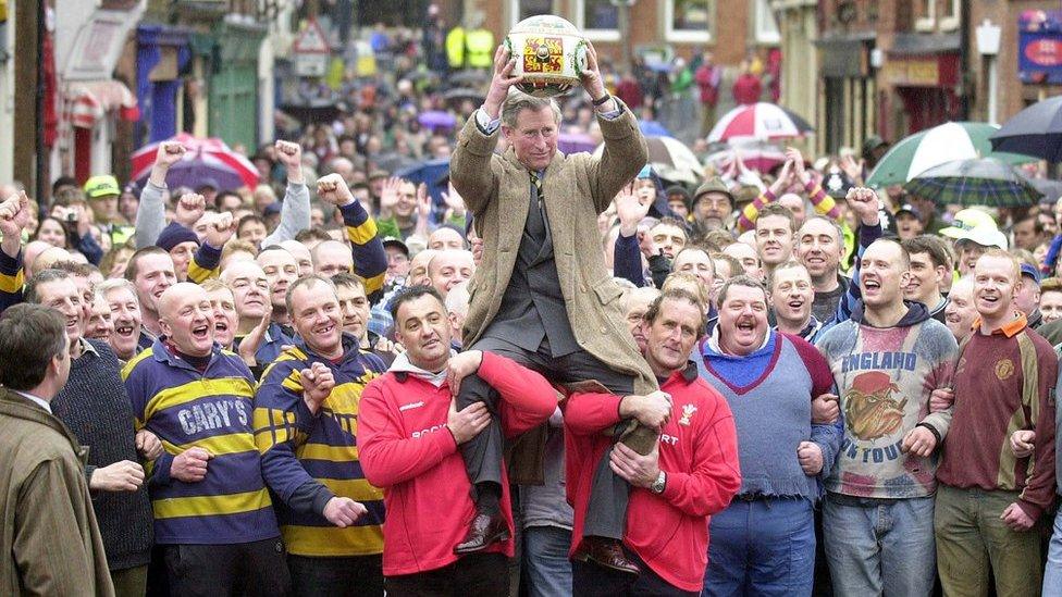 Prince Charles being lifted up holding the ceremonial ball before starting the ancient Royal Shrovetide Football game, in Ashbourne, Derbyshire