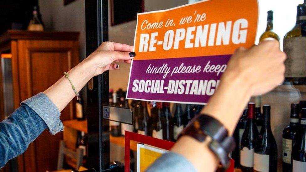 Woman in mask places sign on door