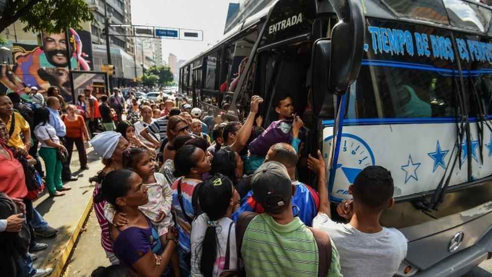 A crowded bus in Caracas with a huge queue outside