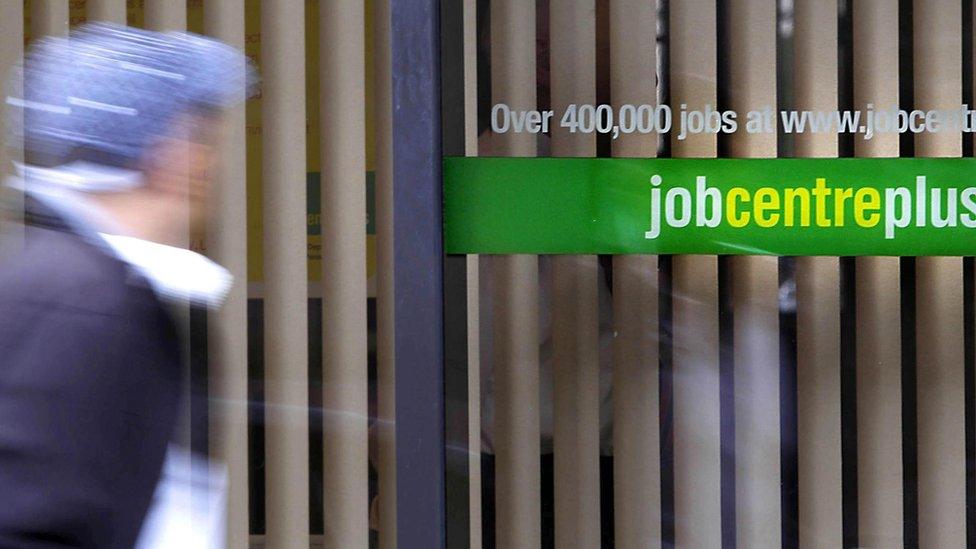 Man passing a jobcentreplus office - blurred