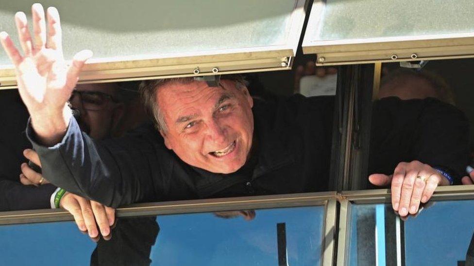 Brazil's former President Jair Bolsonaro waves at Brasilia International Airport as he returns from self imposed exile in Florida, U.S., after the defeat in last year's election, in Brasilia, Brazil March 30, 2023.