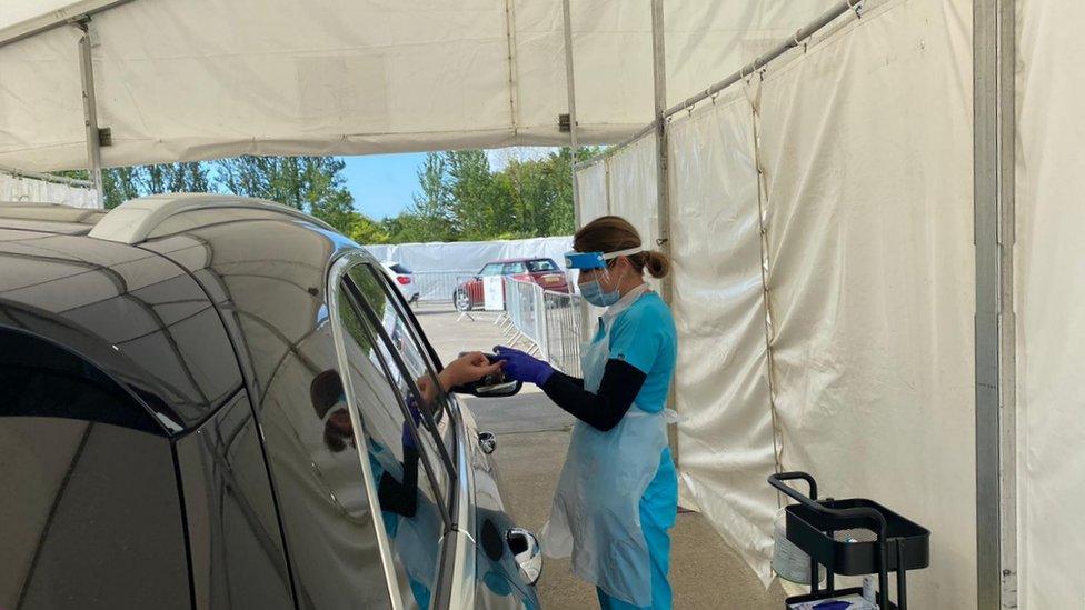 Person having finger prick test through car window