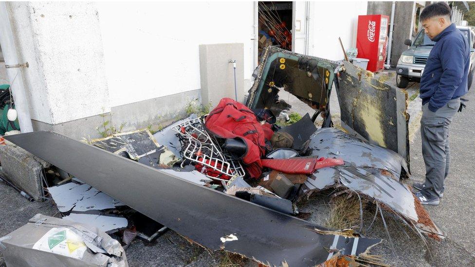 Man looking at pile of wreckage